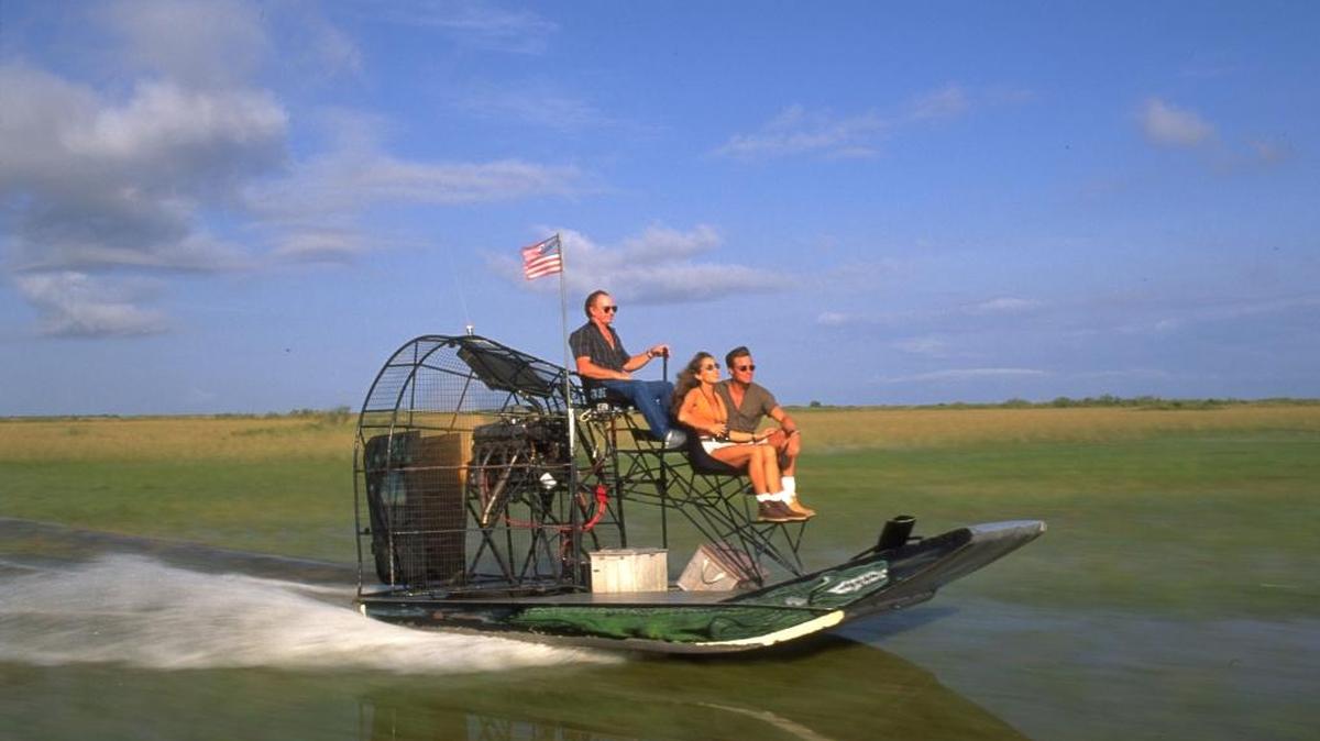 Unos turistas paseando en barca por los everglades de Miami.