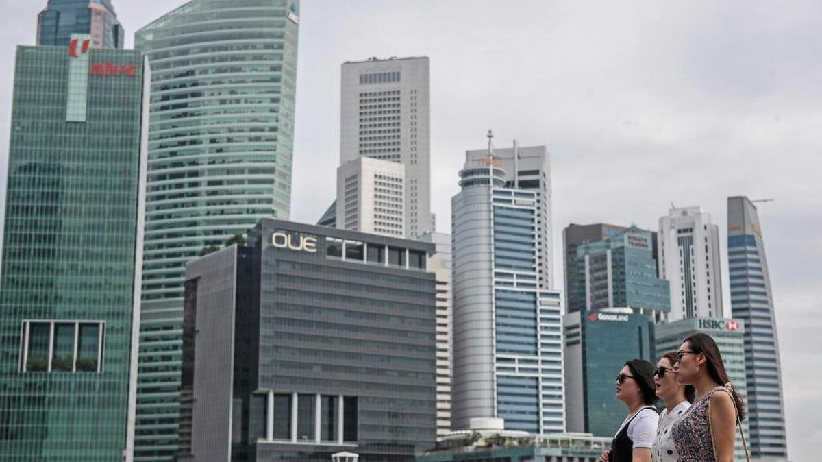 Turistas caminan frente al distrito financiero en Singapur.