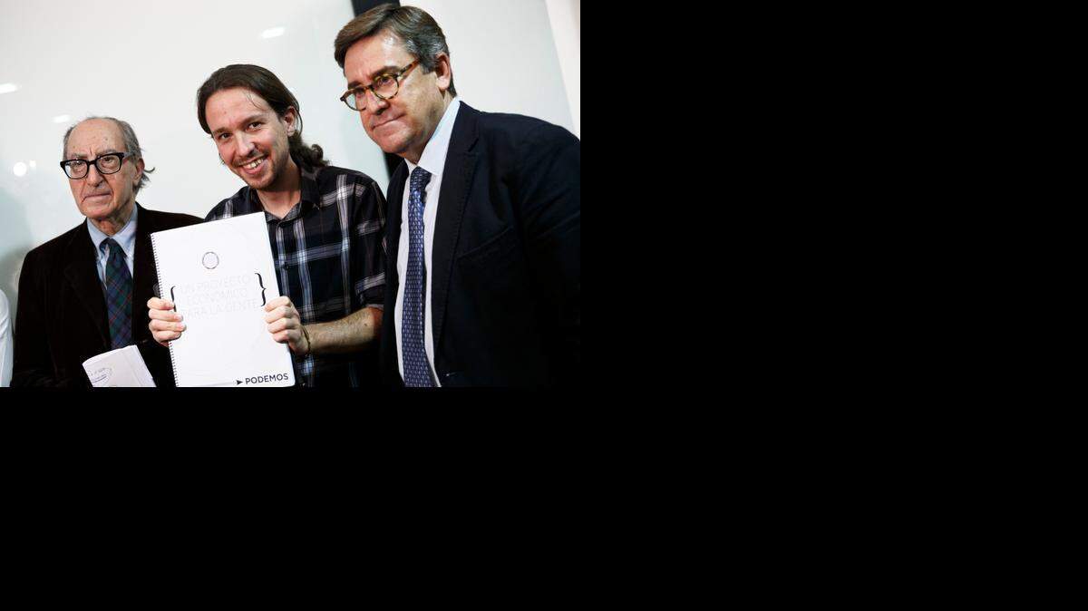 
PABLO IGLESIAS, secretario general de Podemos, en el centro, con su ‘Un proyecto económico para el Pueblo’ escrito por los economistas Vincenc Navarro, izq., y Juan Torres, der., en Madrid.


