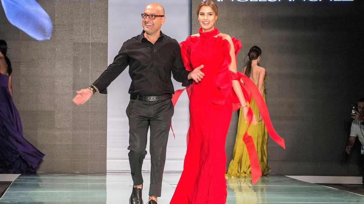 El diseñador venezolano Ángel Sánchez camina junto a una de sus modelos al término de su desfile, el domingo 4 de junio, durante la Semana de la Moda en Miami 2017, en el Ice Palace de Miami.