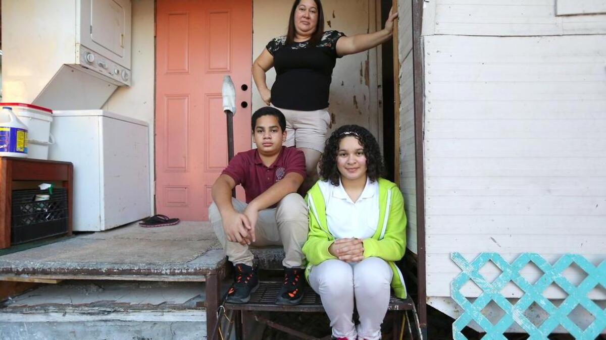 Elsa Petit y sus hijos Jaime y Sara Padilla en su casa móvil en el noroeste de Miami. La familia necesita ayuda para reparar la vivienda y nuevos equipos eléctricos.